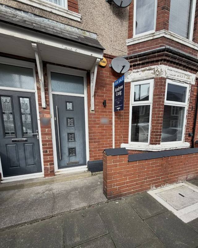 Bay-fronted brick terrace with a grey front door